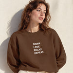 Drink Love Relax Repeat Oversize Sweatshirt – Kahverengi – model üzerinde ön görünüm