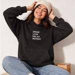 Drink Love Relax Repeat Oversize Hoodie – Siyah – model üzerinde ön görünüm
