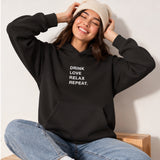 Drink Love Relax Repeat Oversize Hoodie – Siyah – model üzerinde ön görünüm